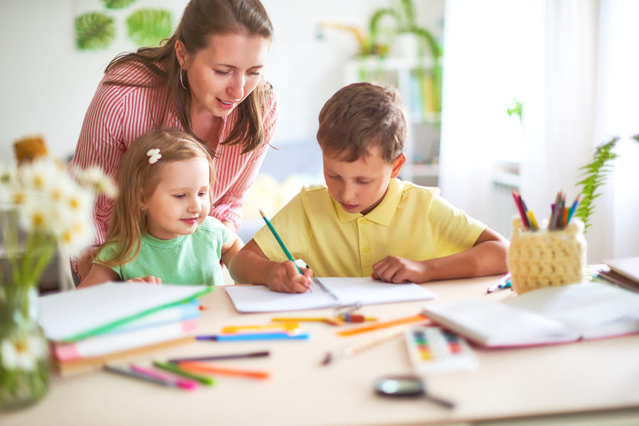 mother-daughter-son-draws-pencil-sheet-paper-sitting-home-table-bright-room (1).jpeg